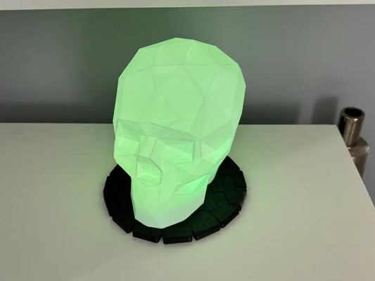 Skull Headset Stand LED Totenkopf Lampe & Kopfhörerhalter auf einem Tisch im grünen Licht.