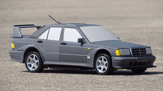RC Mercedes-Benz 190E Evo II Karosserie Show Edition im Maßstab 1:12, graues Modellauto auf betoniertem Untergrund.