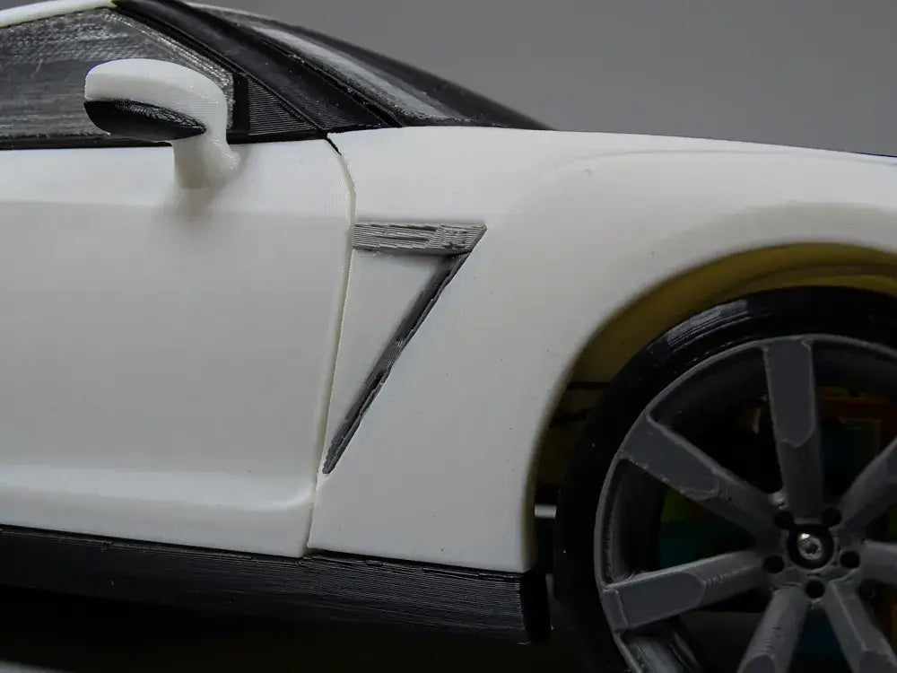Detailansicht des weißen Nissan GT-R R35 Performance Edition Modells mit sportspezifischen Merkmalen.